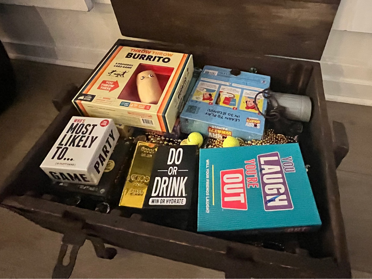Modern party and group games displayed in a gold-filled pirate treasure chest at Gaspar’s Luxury Estate in South Tampa.