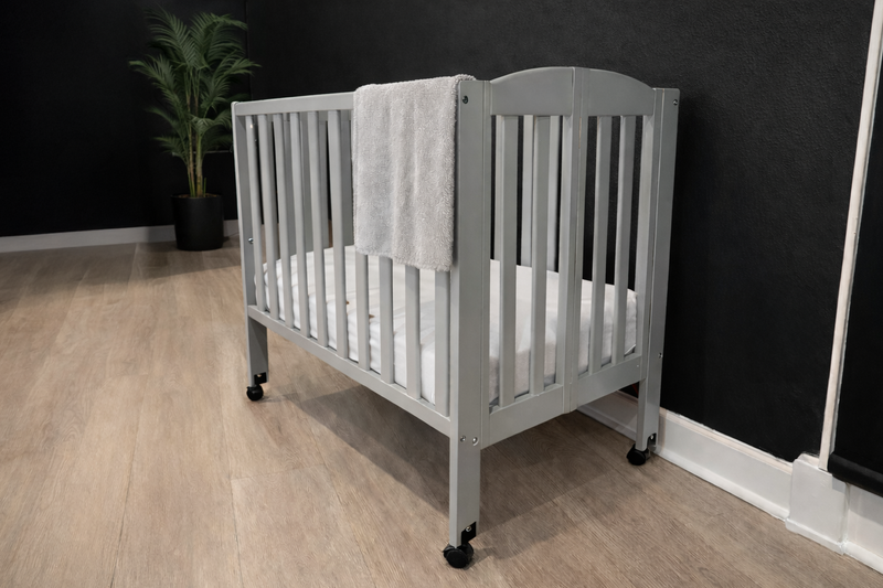 Complimentary gray portable crib with white mattress available for guests at Gaspar's Luxury Estate in Tampa.